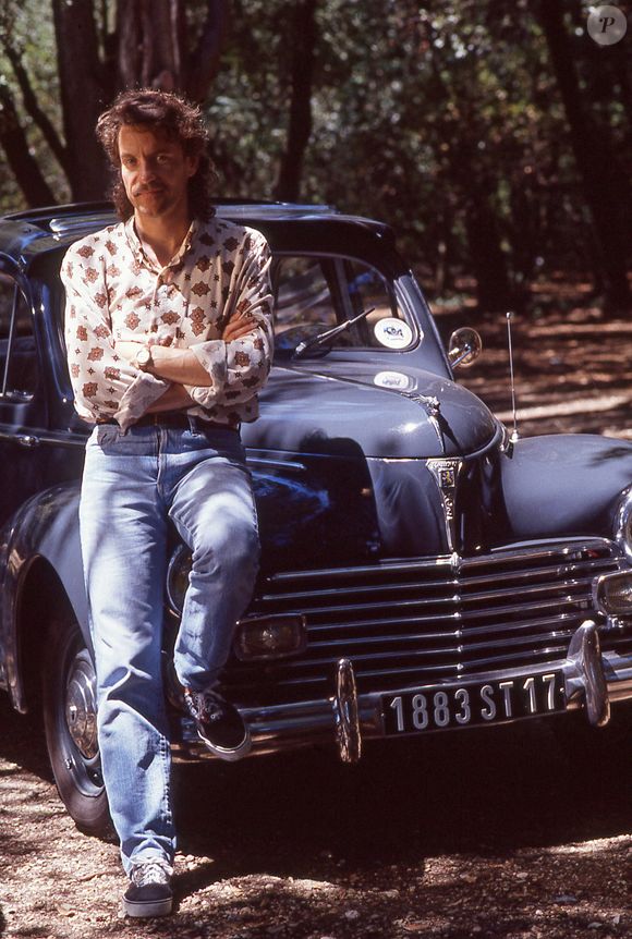 Francis Cabrel pose à côté d'une Peugeot 203 lors des Francofolies de La Rochelle en juillet 1990. Photo par Pascal Baril/ABACAPRESS.COM