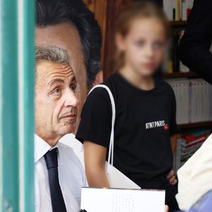 L'ancien président de la République française Nicolas Sarkozy dédicace son livre "Le temps des Combats" sous l'oeil attentif de sa fille Giulia à la Librairie du Marché à Deauville, France, le 1er septembre 2023. © Denis Guignebourg/Bestimage