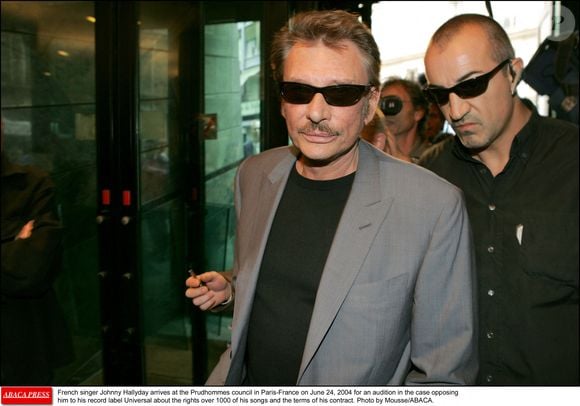 Le chanteur français Johnny Hallyday arrive au conseil des Prudhommes à Paris-France le 24 juin 2004 pour une audition dans le procès qui l'oppose à sa maison de disques Universal au sujet des droits sur 1000 de ses chansons et des termes de son contrat. Photo par Mousse/ABACA.