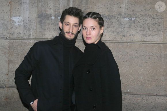 Pierre Niney et sa compagne Natasha Andrews  arrivent au défilé "H&M - Collection prêt-à-porter printemps-été 2018" au musée des arts décoratifs de Paris, le 28 février 2018.