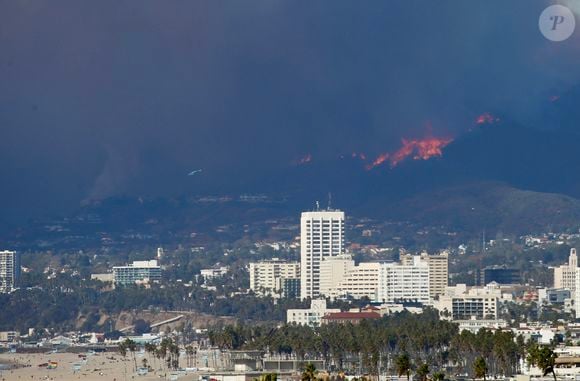 L'incendie de Pacific Palisades brûle à Los Angeles. Il pourrait s'agir de la pire catastrophe de l'histoire de l'Etat de Californie. Un énorme panache de fumée est visible derrière l'aéroport LAX, les résidents inquiets observent à distance, deux avions de lutte contre les incendies Super Scooper recueillent de l'eau dans l'océan Pacifique pour la déverser sur le feu.