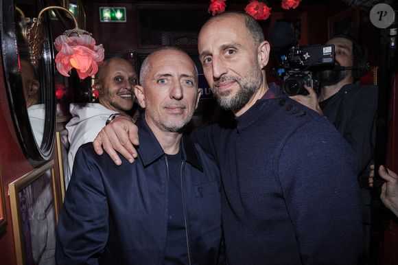 Exclusif - Gad Elmaleh et son frère Arié Elmaleh - Inauguration du Michou Comedy Club avec Gad Elmaleh à Paris le 17 mars 2025. 
Le cabaret transformiste parisien Michou, créé en 1957, est devenu lundi soir un club dédié au stand-up, à l'initiative de son nouveau propriétaire Gad Elmaleh, une aventure qui relève "de la main tendue, de la transmission". 
"Il n'y aura jamais de grand joueur sans centre de formation. Et on est à la fois un terrain, un lieu du match, un lieu de vie, d'échange, de rencontres", a ajouté l'humoriste qui a créé un premier comedy club, Le Vig's, à Marseille il y a quelques semaines. 
"Je ressens beaucoup d'émotion. La satisfaction de voir la naissance des carrières, c'est énorme!", pour celui qui "préfère créer des comedy clubs pour découvrir des talents plutôt que d'avoir un jour une rue à (son) nom".
D'une capacité de 80 spectateurs, le Michou Comedy Club est ouvert dans un premier temps du mercredi au samedi, avec l'objectif de programmer des "standupers" en début de carrière toute la semaine.
L'humoriste P. de Saint Sernin, vu le samedi soir dans "Quelle Époque!" sur France 2, était à l'affiche du plateau inaugural.
G. Elmaleh a été choisi par la justice en octobre pour racheter le fonds de commerce de "Chez Michou".
Son fondateur, surnommé Michou, est décédé début 2020. L'établissement a ensuite connu des difficultés financières et a été mis en liquidation judiciaire l'été dernier.
Pour C. Catty-Jacquart, la nièce de Michou, "Gad Elmaleh va continuer à faire vivre le 80 rue des Martyrs, tombé entre de bonnes mains comme Michou l'aurait aimé. On aurait été malheureux que le lieu devienne autre chose qu'un cabaret".
En 2003, Gad Elmaleh, figure francophone de l'humour, a interprété au cinéma le personnage de "Chouchou", un travesti exubérant.
"C'est ici, chez Michou, que j'ai peaufiné l'écriture des scènes de cabaret de mon film", a raconté l'humoriste.
"Le cabaret Michou, c'est une histoire. Je n'avais pas envie de changer quoi que ce soit. On a tout laissé intact, les photos, les cadres dorés typiques sur les murs".
Il s'offre une adresse internationalement connue dont le fondateur, surnommé "le prince bleu de Montmartre", a inspiré "La Cage aux folles" au comédien et auteur J. Poiret dans les années 1970.
Berceau du transformisme et plus petit cabaret de Paris, "Chez Michou" présentait depuis 68 ans un dîner-spectacle avec des travestis surnommés les "Michettes", imitant des vedettes de la chanson et du cinéma comme S. Vartan, A. Girardot, J. Hallyday, M. Mathieu ou Dalida. © Cyril Moreau/Bestimage