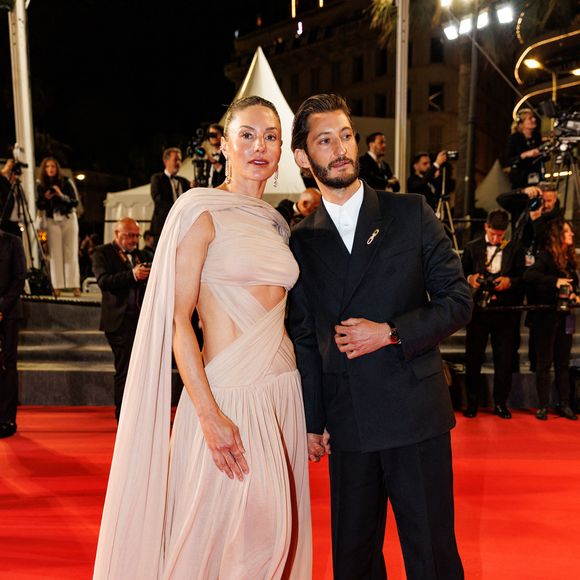 Durant cet événement, le couple a séjourné avec sa compagne Natasha Andrews à l'hôtel Cap Estel.

Pierre Niney et sa compagne Natasha Andrews - Descente des marches du film " Histoires parallèles " lors du 79ème Festival International du Film de Cannes, le 14 mai 2026. Photo par Jacovides-Moreau / Bestimage