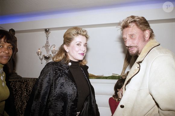 Catherine Deneuve et Johnny Hallyday lors d'une soirée organisée par l'office du tourisme d'Afrique du Sud au restaurant "La Suite", à Paris, le 1 février 2004. © Bestimage