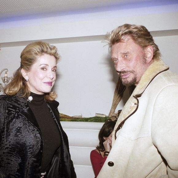 Catherine Deneuve et Johnny Hallyday lors d'une soirée organisée par l'office du tourisme d'Afrique du Sud au restaurant "La Suite", à Paris, le 1 février 2004. © Bestimage