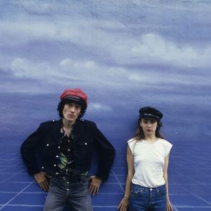 En France, durant leur tournée, Catherine Ringer et Fred Chichin, portant une casquette, debout devant un fond bleu ciel. © Michel Croizard via Bestimage