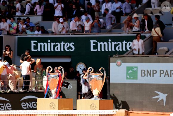 Les véritables stars de ce portrait de famille sont les deux trophées de la Ligue des champions du Paris Saint-Germain.

Atmosphère - Le Paris Saint-Germain (PSG) présente ses trophées de Ligue des champions aux Internationaux de de Tennis de Roland Garros 2026, à Paris, France, le 1er juin 2026. © Jacovides-Moreau/Bestimage