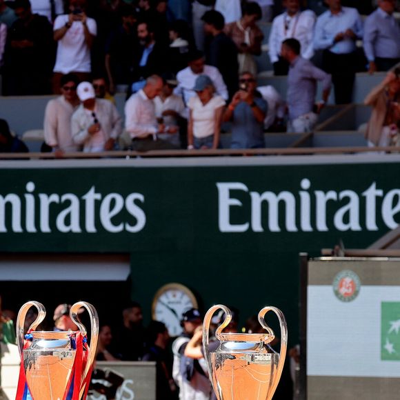 Les véritables stars de ce portrait de famille sont les deux trophées de la Ligue des champions du Paris Saint-Germain.

Atmosphère - Le Paris Saint-Germain (PSG) présente ses trophées de Ligue des champions aux Internationaux de de Tennis de Roland Garros 2026, à Paris, France, le 1er juin 2026. © Jacovides-Moreau/Bestimage