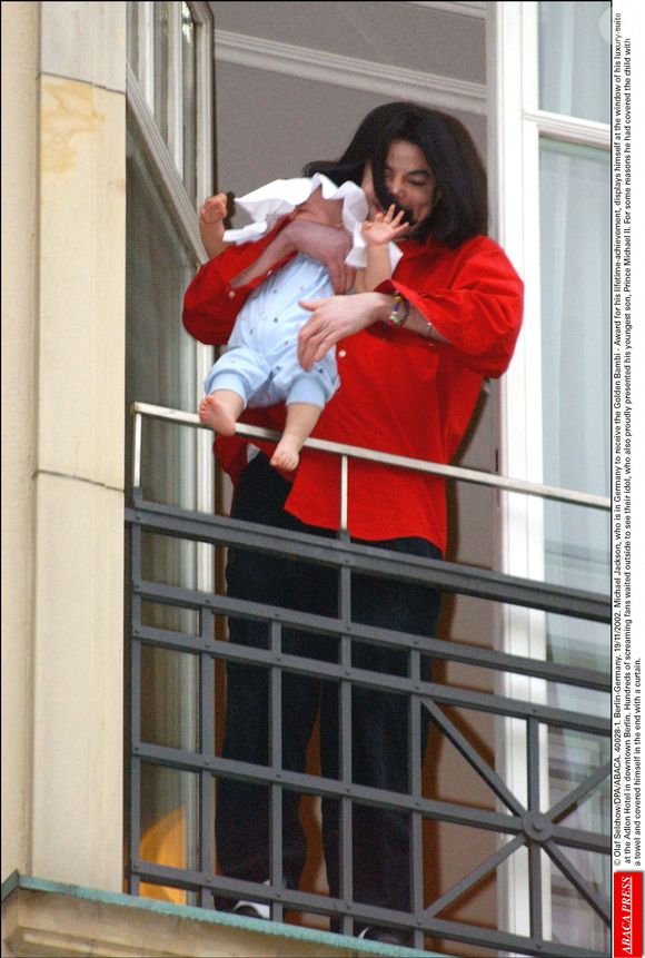 © Olaf Selchow/DPA/ABACA. 40028-1. Berlin-Allemagne. 19/11/2002. Michael Jackson, qui est en Allemagne pour recevoir le Bambi d'or, récompense pour l'ensemble de sa carrière, se montre à la fenêtre de sa luxueuse suite à l'hôtel Adlon dans le centre de Berlin.