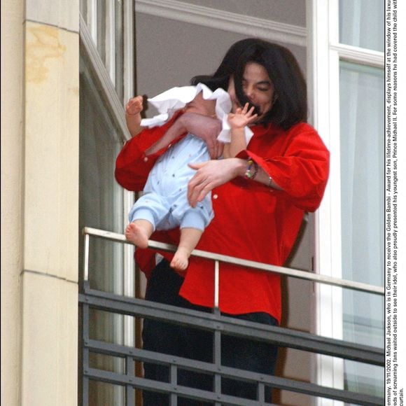 © Olaf Selchow/DPA/ABACA. 40028-1. Berlin-Allemagne. 19/11/2002. Michael Jackson, qui est en Allemagne pour recevoir le Bambi d'or, récompense pour l'ensemble de sa carrière, se montre à la fenêtre de sa luxueuse suite à l'hôtel Adlon dans le centre de Berlin.