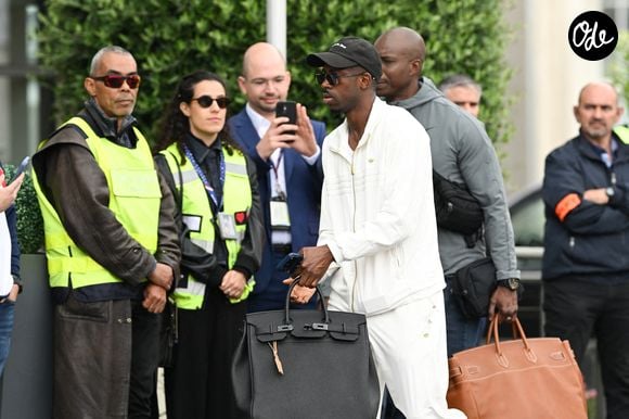 Retour sur l'histoire de cet accessoire devenu incontournable 

Ousmane Dembélé - L'équipe de France de football s'envole du Bourget pour rejoindre Boston aux Etats Unis pour participer à la coupe du monde de la FIFA (du 11 juin au 19 juillet, aux États-Unis, au Canada et au Mexique), le 10 juin 2026. Pierre Perusseau/Bestimage