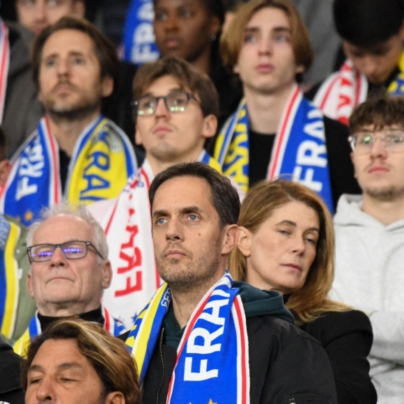 Autre duo père-fils : Grand Corps Malade et l'un de ses deux garçons.

Grand Corps Malade et son fils au Parc des Princes pour assister au match de l'équipe de France de football contre l'Ukraine. 10 ans jour pour jour après les attentats du 13 novembre 2025. Paris, France, 13 novembre 2025. Photo by Florian Poitout/ABACAPRESS.COM