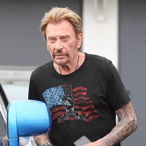 Le chanteur français Johnny Hallyday peine à monter dans son véhicule de luxe et se fait aider par le voiturier pour ouvrir les portes « suicide » de la voiture à Beverly Hills, Los Angeles, Californie, États-Unis, le 4 juin 2015. Photo : GSI/ABACAPRESS.COM
