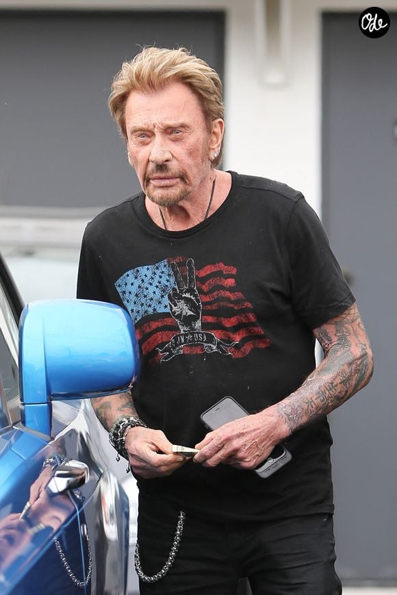 Le chanteur français Johnny Hallyday peine à monter dans son véhicule de luxe et se fait aider par le voiturier pour ouvrir les portes « suicide » de la voiture à Beverly Hills, Los Angeles, Californie, États-Unis, le 4 juin 2015. Photo : GSI/ABACAPRESS.COM