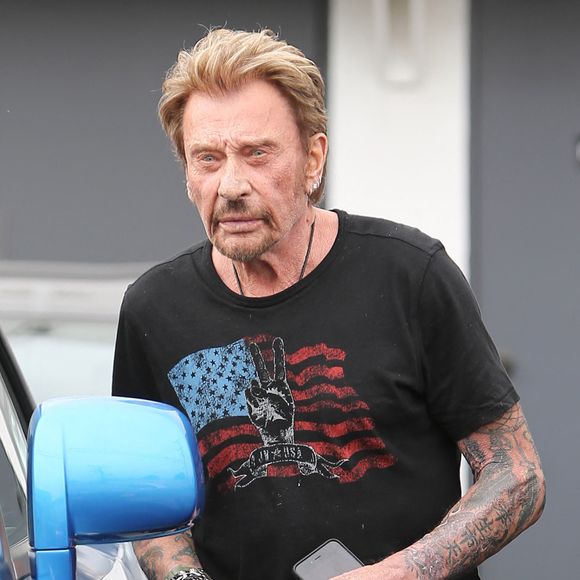 Le chanteur français Johnny Hallyday peine à monter dans son véhicule de luxe et se fait aider par le voiturier pour ouvrir les portes « suicide » de la voiture à Beverly Hills, Los Angeles, Californie, États-Unis, le 4 juin 2015. Photo : GSI/ABACAPRESS.COM