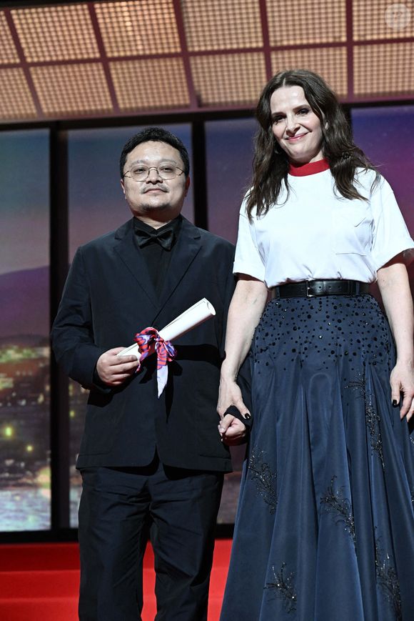 Le réalisateur et scénariste chinois Bi Gan pose sur scène à côté de l'actrice française et présidente du jury du 78e festival de Cannes Juliette Binoche après avoir reçu un Prix spécial lors de la cérémonie de clôture de la 78e édition du Festival de Cannes à Cannes, France, le 24 mai 2025. Photo de David Niviere/ABACAPRESS.COM