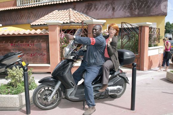 EXCLUSIF. Véronique Genest et Mouss Diouf, acteurs et membres de l'équipe, à moto lors du tournage d'un épisode de la série télévisée "Julie Lescaut" sur TF1 à La-Varenne-Saint-Hilaire, France, le 30 juin 2004. Photo par Laurent Zabulon/ABACA.