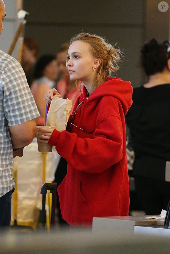 Lily-Rose Depp fait la queue au comptoir "The Coffee Bean" à l'aéroport de Los Angeles, commande puis mange un snack avec une boisson rapidement avant d'aller prendre un avion accompagnée de son garde du corps le 22 mai 2016. Agence / Bestimage