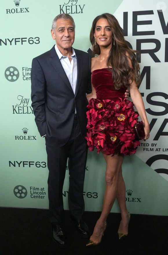 Le bustier est en velours rouge et la jupe est fleurie.
George Clonney et Amal Clooney assistent à la première sur le tapis rouge de « Jay Kelly » lors de la soirée d'ouverture du 63e Festival du film de New York. Alice Tully Hall, Lincoln Center, New York. 29 septembre 2025.  © Sonia Moskowitz Gordon/ZUMA Press Wire