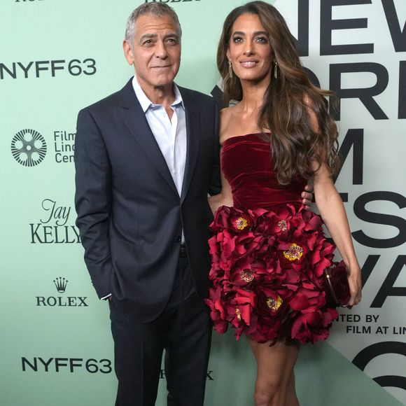 Le bustier est en velours rouge et la jupe est fleurie.
George Clonney et Amal Clooney assistent à la première sur le tapis rouge de « Jay Kelly » lors de la soirée d'ouverture du 63e Festival du film de New York. Alice Tully Hall, Lincoln Center, New York. 29 septembre 2025.  © Sonia Moskowitz Gordon/ZUMA Press Wire