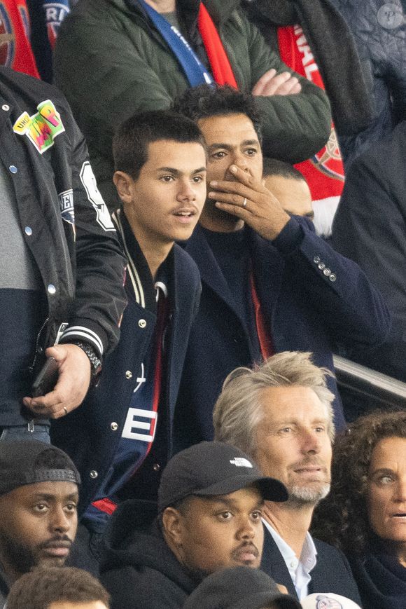 Interrogé sur ses enfants, Léon et Lila, Jamel Debbouze a évoqué avec humour sa lutte contre le temps d’écran.

Jamel Debbouze et son fils Léon Debbouze dans les tribunes lors du match retour de la Ligue Des Champions 2024-2025 (LDC) "PSG - Arsenal" (2-1) au Parc des Princes à Paris le 7 mai 2025.

© Cyril Moreau/Bestimage