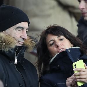 Raymond Domenech et sa femme Estelle Denis dans les tribunes lors du match de Ligue 1 "PSG - OM (3-0)" au Parc des Princes à Paris, le 25 février 2018. AGENCE / BESTIMAGE