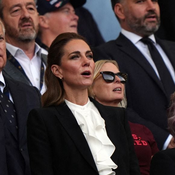 Kate Middleton portait un tailleur noir Alexander McQueen et une chemise à jabot.

La Princesse de Galles (au centre) dans les tribunes pendant l'hymne national lors du match de poule A de la Coupe du monde de rugby féminin 2025 à l'American Express Stadium, Brighton. Samedi 6 septembre 2025. Photo by Ben Whitley/PA Wire/ABACAPRESS.COM