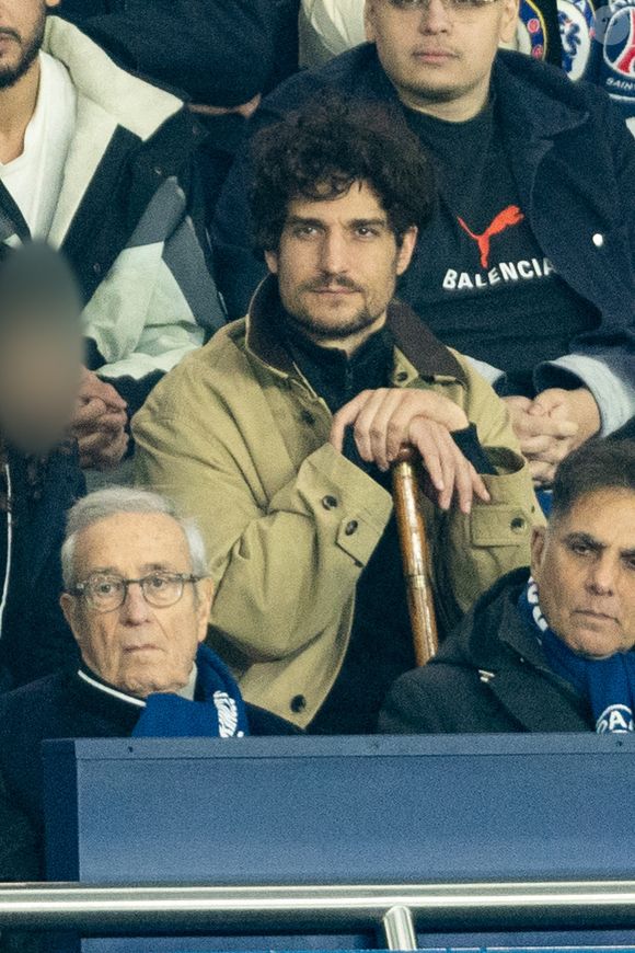 Louis Garrel, Charles Villeneuve - Célébrités dans les tribunes du match de 8ème de finale aller de la Ligue Des Champions 2025-2026 (LDC) "PSG - Chelsea (5-2)" au Parc des Princes à Paris le 11 mars 2026. © Cyril Moreau/Bestimage
