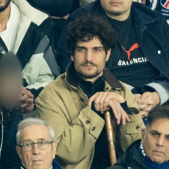 Louis Garrel, Charles Villeneuve - Célébrités dans les tribunes du match de 8ème de finale aller de la Ligue Des Champions 2025-2026 (LDC) "PSG - Chelsea (5-2)" au Parc des Princes à Paris le 11 mars 2026. © Cyril Moreau/Bestimage