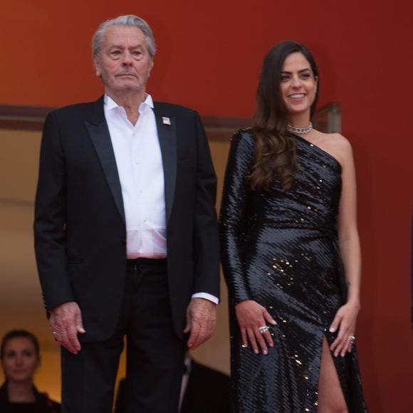 Alain Delon (Palme d'Or d'Honneur du 72ème festival de Cannes avec un badge Paris Match d'une ancienne couverture du magazine titrant "Alain Delon, mes deux amours, Rosalie et Anouchka) et sa fille Anouchka (Robe Elie Saab) - Montée des marches du film "A Hidden Life" lors du 72ème Festival International du Film de Cannes. Le 19 mai 2019 (Backgrid UK/ Bestimage).