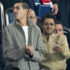 Jamel Debbouze et son fils Léon, Cindy Bruna et son futur mari Serge Ibaka - Célébrités dans les tribunes du match de Ligue des Champions entre le PSG contre le Bayern de Munich (1-2) au Parc des Princes à Paris le 4 novembre 2025. © Cyril Moreau/Bestimage