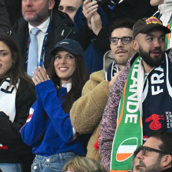 Très médiatisés mais discrets, Iris Mittenaere et Antoine Dupont préfèrent vivre leur relation loin des projecteurs.

Iris Mittenaere, Jean Dujardin, Oli - Célébrités dans les tribunes du match d'ouverture du Tournoi des six nations : France-Irlande (36-14) au Stade de France à Saint-Denis le 5 février 2026. © Lionel Urman/Bestimage