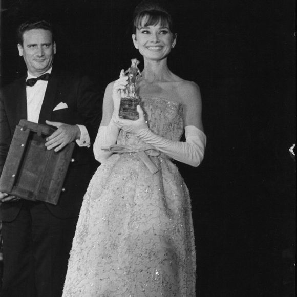 7 juillet 1962 - Hier soir, à Taormine, dans le magnifique cadre du théâtre gréco-romain, s'est déroulée la cérémonie de remise des prix « David di Donatello » aux acteurs étrangers et italiens pour leurs meilleurs films. Des personnalités du cinéma, des actrices et des acteurs étaient présents à la cérémonie. La photo montre l'actrice américaine Audrey Hepburn recevant le « David di Donatello » pour son rôle principal dans « Breakfast at Tiffany's » (Crédit photo : © Keystone Press Agency/ZUMA Press Wire)