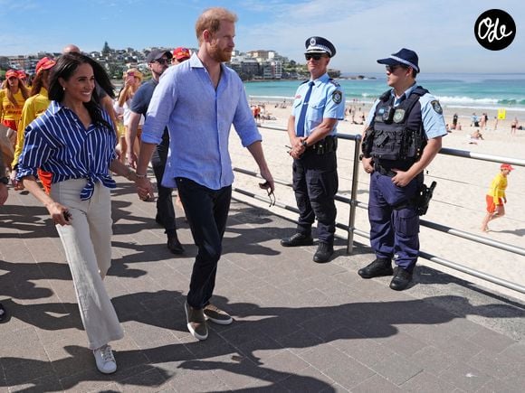 Le duc et la duchesse de Sussex se promènent sur la promenade après avoir rencontré des secouristes bénévoles du Bondi Surf Bathers' Life Saving Club, lors d'une visite à Bondi Beach, vendredi 17 avril 2026.  Crédit photo : Jonathan Brady/PA Wire