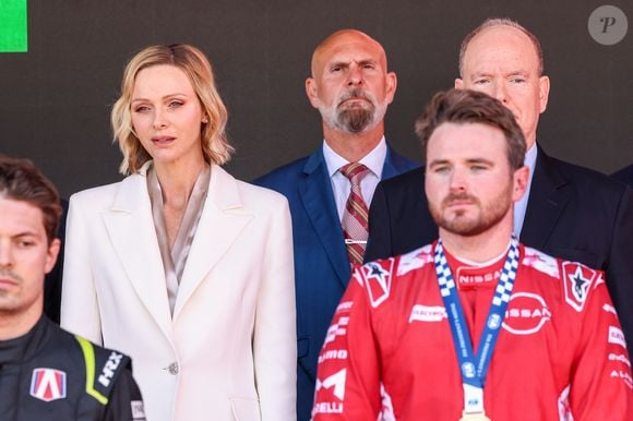 Pour la cérémonie sur le podium, Charlene de Monaco portait un tailleur blanc élégant assorti d’escarpins.

Le prince Albert II et la princesse Charlène de Monaco sur le podium lors de la remise de prix du E-Prix de Monaco du Championnat du monde FIA de Formule E 2026 sur le circuit de Monaco à Monte-Carlo, Monaco, le 17 mai 2026. Le pilote britannique Oliver Rowland remporte la deuxième course du week-end à Monaco devant le Brésilien Felipe Drugovich et le Portugais Antonio Félix Da Costa. © Claudia Albuquerque/Bestimage