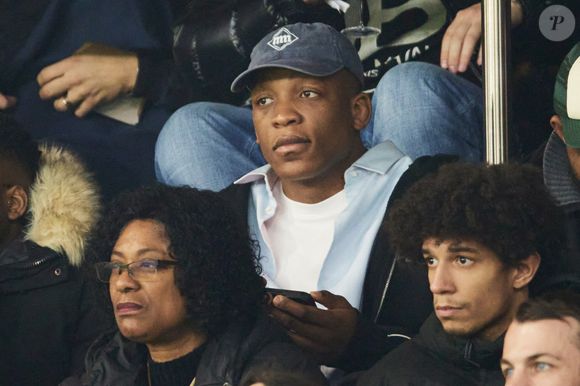 Cameron Woki dans les tribunes lors du match de Ligue Des Champions 2024-2025 (LDC) "PSG - Brest (7-0)" au Parc Des Princes, le 19 février 2025.
© Cyril Moreau/Bestimage