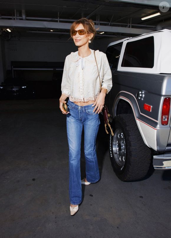 22/03/2026 : Los Angeles, CA Bella Hadid a affiché un sourire radieux à son arrivée au Soho House Holloway pour le lancement de son parfum Orebella Jasmine Blues. Elle portait un chemisier en dentelle avec un jean, des talons Chanel vintage et un sac Chloe.

Photo : Backgrid USA / Bestimage