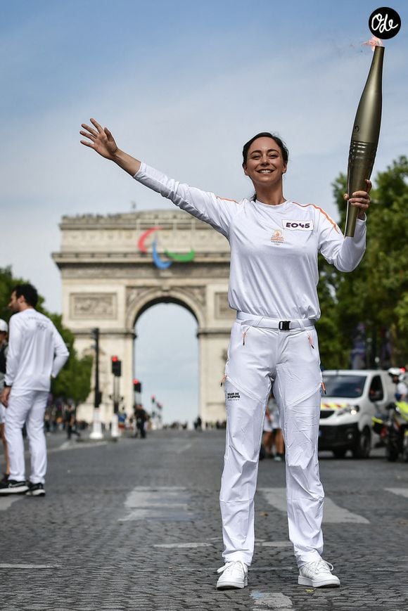 La pâtissière française Nina Metayer porte la flamme olympique sur les Champs-Élysées, devant l'Arc de Triomphe, lors du relais de la flamme olympique à Paris, le 15 juillet 2024. Photo de Firas Abdullah/ABACAPRESS.COM