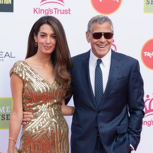 Le couple avait également promis de participer à la reconstruction de Brignoles si leur propriété venait à être touchée.

George Clooney, son épouse Amal Clooney et la mère de celle-ci, Baria Alamuddin, sont aperçus alors qu'ils assistent à la célébration du King’s Trust au Royal Albert Hall de Londres, en Angleterre. 
Backgrid UK/ Bestimage