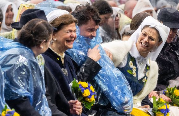 Alors que les festivités battaient leur plein, une pluie soudaine a obligé les membres de la famille à s’emmitoufler dans des ponchos en plastique.

Andreas Norlen, La reine Silvia de Suède, la princesse Victoria de Suède lors des célébrations de la Fête nationale à Stockholm le 6 juin 2025. Photo par Dana Press / Bestimage