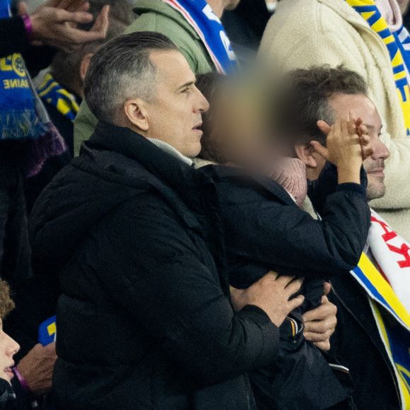 Guillaume Canet et ses enfants Marcel et Louise dans les tribunes du match de qualification de la Coupe du monde 2026 entre la France contre l'Ukraine (4-0) au Parc des Princes à Paris le 13 novembre 2025. © Cyril moreau/Bestimage