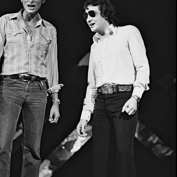 Archives - Johnny Hallyday et Michel Sardou sur le plateau de l'émission de TF1 "Numero 1 à Michel Sardou" en 1975.