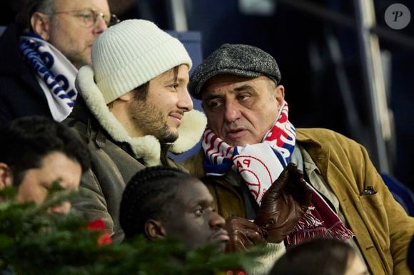 Vianney et son père dans les tribunes du match de Ligue 1 McDonald's opposant le Paris Saint-Germain (PSG) à Lyon (3-1) au Parc des Princes à Paris le 15 décembre 2024. © Cyril Moreau/Bestimage