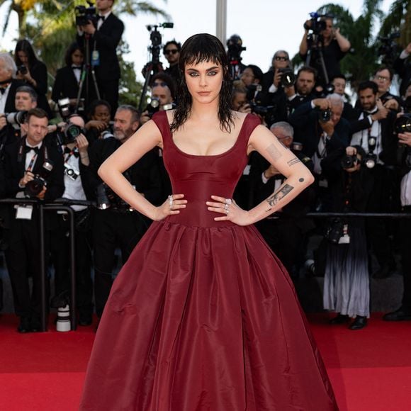 Place à une chevelure brune, effet mouillé, avec une frange étonnante, détaille le "Daily Mail", qui parle d'une "transformation capillaire spectaculaire". Méconnaissable, elle a également misé sur un maquillage "smokey-eye audacieux", et une robe rouge bouffante.

Cara Delevingne - Montée des marches du film "The history of sound" lors du 78ème Festival International du Film de Cannes, au Palais des Festivals à Cannes. Le 21 mai 2025. © Jacovides-Moreau / Bestimage