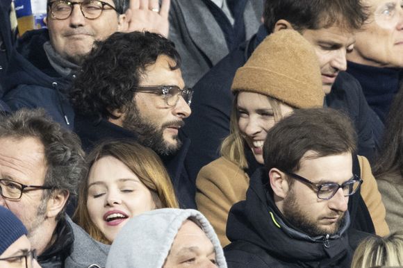 Maxim Nucci (Yodelice) et sa compagne Isabelle Ithurburu dans les tribunes lors du match de rugby du Tournoi des 6 Nations opposant la France à l'Angleterre au stade de France, à Saint-Denis, Seine Saint-Denis, France, le 19 mars 2022. La France s'offre le grand chelem dans le Tournoi des six nations, après sa victoire 25-13 contre l'Angleterre. © Cyril Moreau/Bestimage