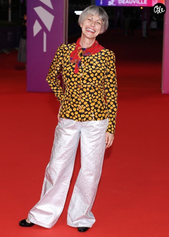 Lio a quant à elle opté pour la couleur avec une veste noire à imprimé floral jaune, ornée de boutons dorés, signée Yves Saint Laurent, avec son pantalon argenté et un foulard rouge assortis aux motifs de son haut. 

Lio, présidente du jury de la révélation - Arrivées à la cérémonie de clôture de la 52ème édition du Festival du Cinéma Américain de Deauville le 12 septembre 2026. © Denis Guignebourg / Bestimage