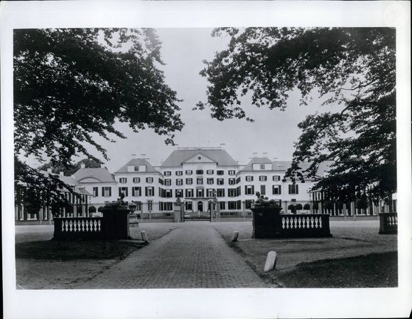 Les rapports suggèrent que le futur roi a payé la propriété et toutes les nouvelles rénovations nécessaires lui-même.

1975 - Palais Het Loo.  L'avenir du couple de mariés:  Une ferme seigneuriale construite au XVe siècle dans un "loo", une clairière, ouvre l'histoire de ce château majestueux, si bien situé dans les bois séculaires près d'Apeldoorn, qu'il sera la première résidence temporaire de la princesse Margriet et de son mari.  Johan Bentinck, maître de chasse de la Veluwe, fit construire un petit château à l'emplacement de la ferme, propriété de son père, et la famille y habita jusqu'en 1548.  Il devint ensuite la demeure de cinq familles importantes de Gueldre, puis fut acheté en 1685 par Guillaume III, stathouder de Hollande et roi d'Angleterre, qui souhaitait pratiquer son sport favori, la chasse, dans les bois environnants.  Peu de temps après, il décida que le modeste pavillon de chasse devait faire place à un palais digne de son propriétaire et, avec l'aide des 6.000 hommes de la garnison voisine de Hattum, il fut transformé en deux ans (1686-1688) en un édifice imposant entouré de lacs ornementaux, de jardins et de parcs conçus par le célèbre paysagiste français Le Nôtre.  Dans les années qui suivirent, de longues ailes furent ajoutées à l'avant et à l'arrière du corps de bâtiment principal, et il en resta ainsi pendant plus de deux siècles.  Après la mort de Guillaume III en 1702, le palais fut occupé par Guillaume V et plus tard par Louis Napoléon, nommé roi de Hollande par son frère, l'empereur Napoléon.  Louis fit réparer les dégâts du Palais qui, comme toutes les autres propriétés de la Maison d'Orange, avait souffert des dommages causés par les soldats français.  Le Palais Het Loo était également une résidence d'été préférée du roi Guillaume III et de son épouse Sophie.  Au début de ce siècle, l'architecte du gouvernement H.C. Peertes a effectué des modifications importantes au palais: un étage supplémentaire a été ajouté à la partie centrale du bâtiment, de nouvelles ailes ont été ajoutées et l'apparence des dépendances a été modifiée.  Keystone USA Collection / Bestimage