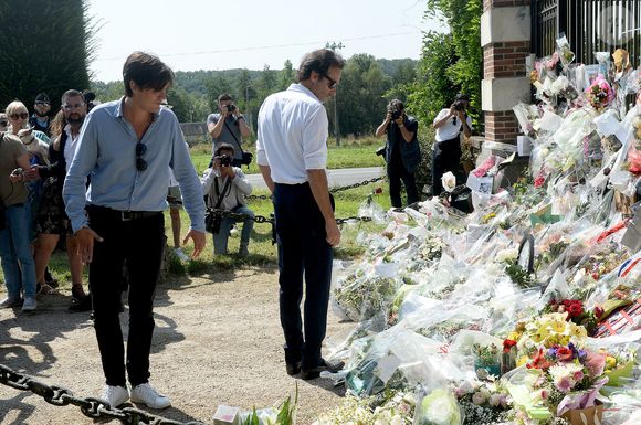 Anthony Delon et son demi-frère Alain-Fabien découvrent les hommages devant les grilles de la propriété de Douchy, quelques heures avant les obsèques de leur père, A.Delon, le 24 août 2024.  © Agence / Bestimage