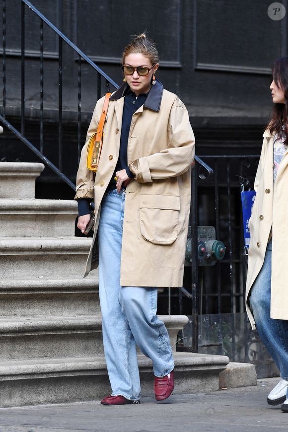 04/03/2026 : Gigi Hadid est élégante lors de sa sortie à New York. Le mannequin de 30 ans portait un chemisier noir sous un trench kaki avec un jean en détresse, un sac à bandoulière jaune avec une lanière en cuir beige et des mocassins rouges Miu Miu.

Photo : The ImageDirect / Bestimage