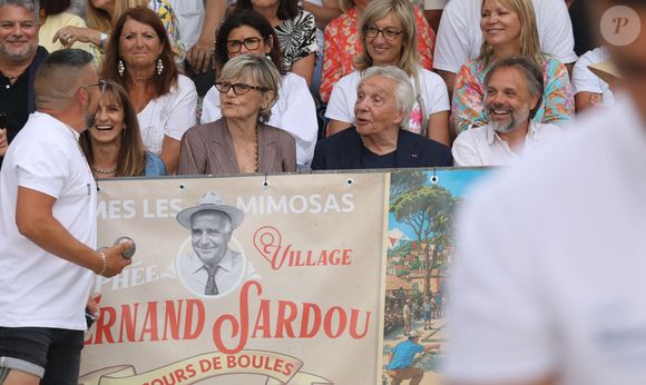 Semi-exclusif - Michel Sardou et sa femme Anne-Marie Périer, Romain Sardou - Michel Sardou rend hommage à son père en famille lors du premier trophée de pétanque "Fernand Sardou" à Bormes-les-Mimosas le 29 mai 2026. Le célèbre chanteur est venu en famille avec sa femme, son fils Romain avec son fils de deux ans et demi et de sa compagne enceinte de son deuxième enfant.
La première édition du Trophée Fernand Sardou est organisée du 29 au 31 mai au coeur du village de Bormes les Mimosas. Une initiative portée par Michel et son fils Romain, pour rendre hommage à leur illustre parent Fernand Sardou au travers d'un tournoi de pétanque.
En lien avec la municipalité et l'Amicale Bouliste Borméenne (ABB), un premier Trophée Fernand Sardou sera organisé avec deux grands temps forts : Le vendredi, dès 18h, un tournoi d'exhibition sera proposé et verra s'affronter 16 triplettes. Puis un concours fédéral à pétanque sera organisé le weekend et ouvert à tous les amateurs. 128 équipes seront réparties sur les sites les plus emblématiques du village, à savoir au boulodrome de la place Saint-François, mais aussi au parc Cigalou, sur le site du château et à l'ancien stade. © Franz Chavaroche/Bestimage